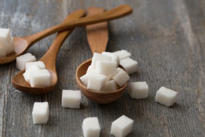 close up of three different types of sugar, white refined granulated sugar, brown cane sugar and sug