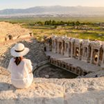 Hierapolis ancient city Pamukkale Turkey, young woman with hat watching sunset by the ruins Unesco