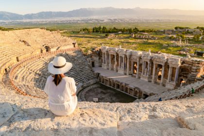 Hierapolis ancient city Pamukkale Turkey, young woman with hat watching sunset by the ruins Unesco