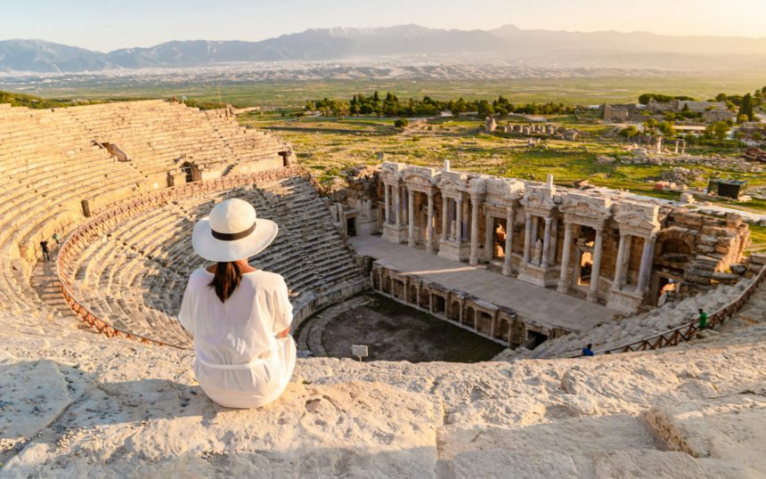 Hierapolis ancient city Pamukkale Turkey, young woman with hat watching sunset by the ruins Unesco