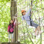 Little girls playing in tree top adventure park