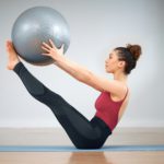 Pilates can be challenging. Shot of a young woman doing core exercises using a medicine ball.