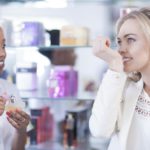 Sales woman assisting customer choosing a new perfume